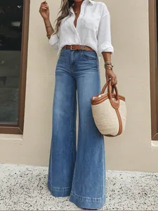 Chic retro washed blue wide-leg denim jeans styled with a white shirt and tote