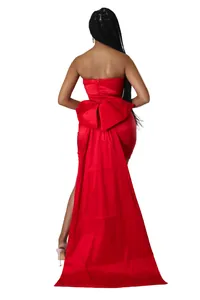Close-up back view of a red strapless evening dress featuring a large bow and long train