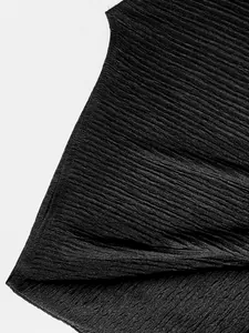 Dettaglio macro del tessuto plissettato nero traspirante del completo gonna elegante.