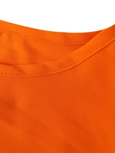 Gros plan de l'encolure ronde à double couture et de la texture du tissu orange de la robe