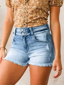 Zoom sur un short en jean taille haute avec ourlets effilochés et fermeture à double bouton.