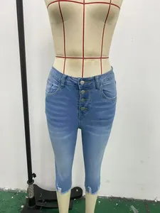 Detalle del pantalón capri vaquero ajustado con cuatro botones y bajos deshilachados.