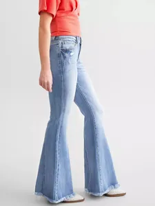 Vista laterale di jeans svasati azzurri slim fit da donna con orli sfrangiati eleganti