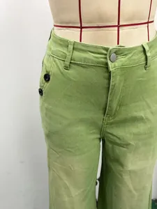 Gros plan sur un pantalon en jean vert à taille haute et jambes larges avec boutons