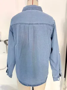 Detailed back view of a stylish light blue long-sleeved denim shirt on a mannequin