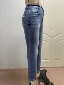 Close-up detail of women's slim stretch denim jeans with elegant floral embroidery