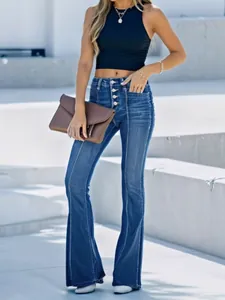 Detailopname van modieuze blauwe damesjeans met uitlopende pijpen en knoopsluiting