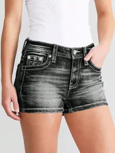 Detalle de pantalones cortos vaqueros de mujer en lavado oscuro con costuras en contraste