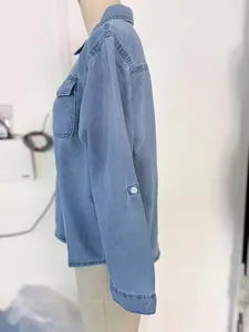 Detailed side view of a casual light blue long sleeve denim button-down shirt for women