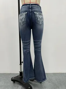 Dettaglio del ricamo etnico sulle tasche posteriori di questi jeans a zampa blu da donna.