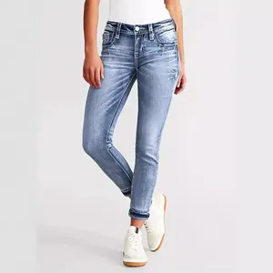 Detailed view of women's skinny stretch jeans with elegant star embroidery on the pocket.