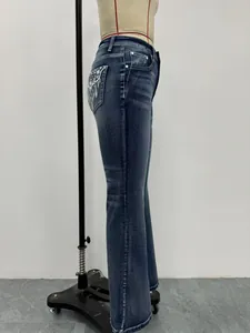Vista laterale di eleganti jeans a zampa ricamati blu scuro su un manichino sartoriale