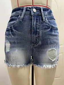 Detailopname van high-waisted denim shorts met distressed details en gerafelde zoomranden.