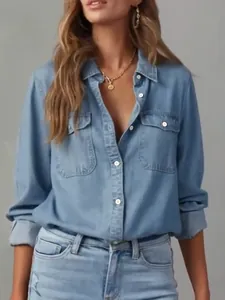 Detail of a casual light blue denim shirt with lapel collar and chest pockets