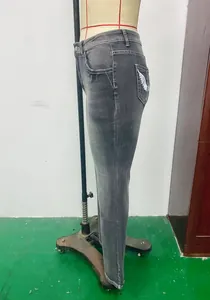 Side view detail of grey high-stretch washed denim slim jeans with wing embroidery