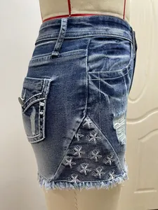 Close-up van het witte sterborduurwerk en gescheurde details op blauwe denim korte broek