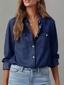 Detailed view of a stylish dark blue long-sleeved denim shirt featuring lapel and pockets.