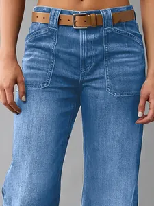 Gros plan d'un jean large bleu pour femme avec ceinture marron et poches plaquées.