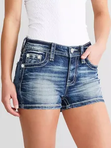 Vista de detalle de pantalones cortos vaqueros ajustados con costuras blancas.