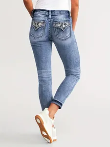 Back view detail of slim fit stretch denim jeans with floral embroidery on pockets.