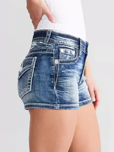 Detalle lateral de pantalones cortos vaqueros ajustados con lavado y tachuelas