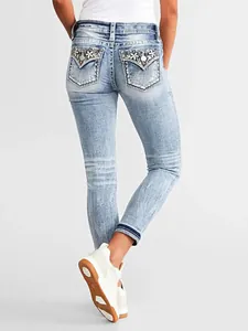 Detailed view of women's slim-fit jeans featuring exquisite floral back pocket embroidery