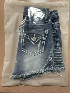 Detailopname van distressed blauwe denim shorts met sterborduurwerk in verpakking