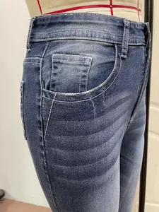 Close-up detail of side pocket with white contrast stitching on blue denim jeans