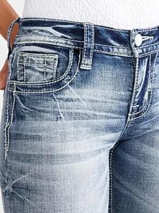 Close-up detail of women's slim fit blue denim jeans with heavy white contrast stitching.
