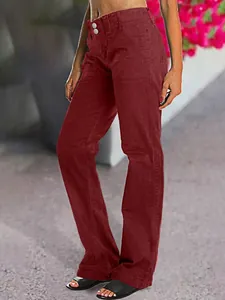 Gros plan sur un pantalon en jean rouge à coupe droite pour femme avec double bouton.