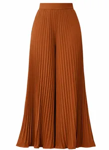 Detail of high-waisted pleated wide-leg trousers in burnt orange with elegant drape