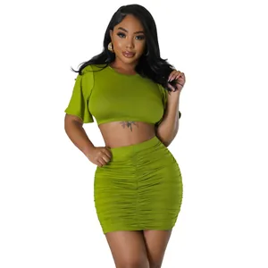 Close-up detail of sexy lime green two-piece outfit featuring crop top and ruched skirt