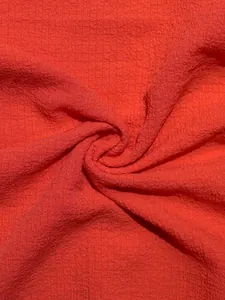 Primer plano de tela seersucker roja texturizada para conjunto de dos piezas mujer.