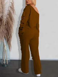 Detail view of brown two-piece set with ripped sleeves and off-shoulder sweatshirt