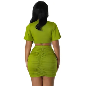 Back view of a lime green two-piece ruched mini skirt set with short sleeve crop top.