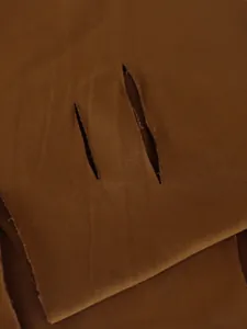 Macro view of the distressed vertical ripped design on brown sports fabric detail