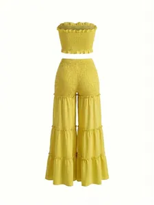 Detalle de un conjunto amarillo de mujer con top palabra de honor y pantalón ancho.