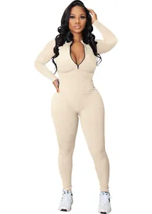 Detailed view of a beige ribbed long-sleeve athletic jumpsuit with front zipper closure
