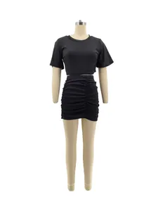 Detail of black two-piece set featuring short sleeve crop top and ruched bodycon skirt