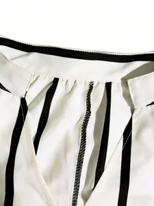 Primer plano del escote en V y costuras de un vestido camisero de rayas blancas