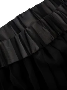Detail of high elastic waistband and pleated texture on black resort trousers