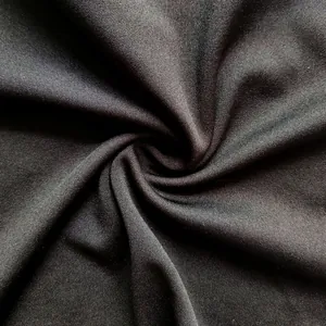 Macro detail showing the soft knit texture and drape of black fabric for women's suits