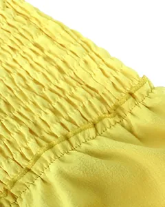 Primer plano del tejido elástico amarillo con detalles de costura para conjunto mujer.