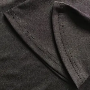 Close-up detail of high-quality double stitching on the hem of a black stretch fabric outfit