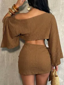 Back view of brown textured two-piece resort set with one-shoulder top and mini skirt