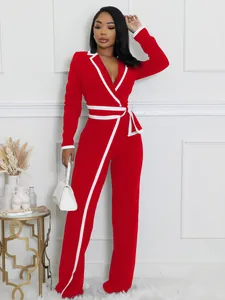Detalle del mono rojo de manga larga con ribetes blancos y cinturón elegante a la cintura