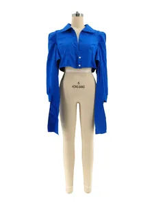 Frontal detail view of a royal blue cropped shirt featuring structured shoulders on a mannequin