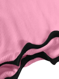 Detail view of pink ribbed fabric with black wavy lettuce edge hem on a summer tank dress