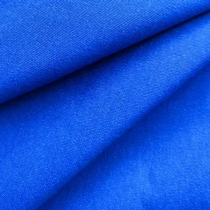 Macro detail view of vibrant blue twill fabric texture for elegant women's fashion shirt