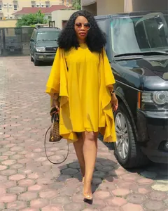Robe ample jaune grande taille avec manches chauve-souris dans un cadre de rue urbain